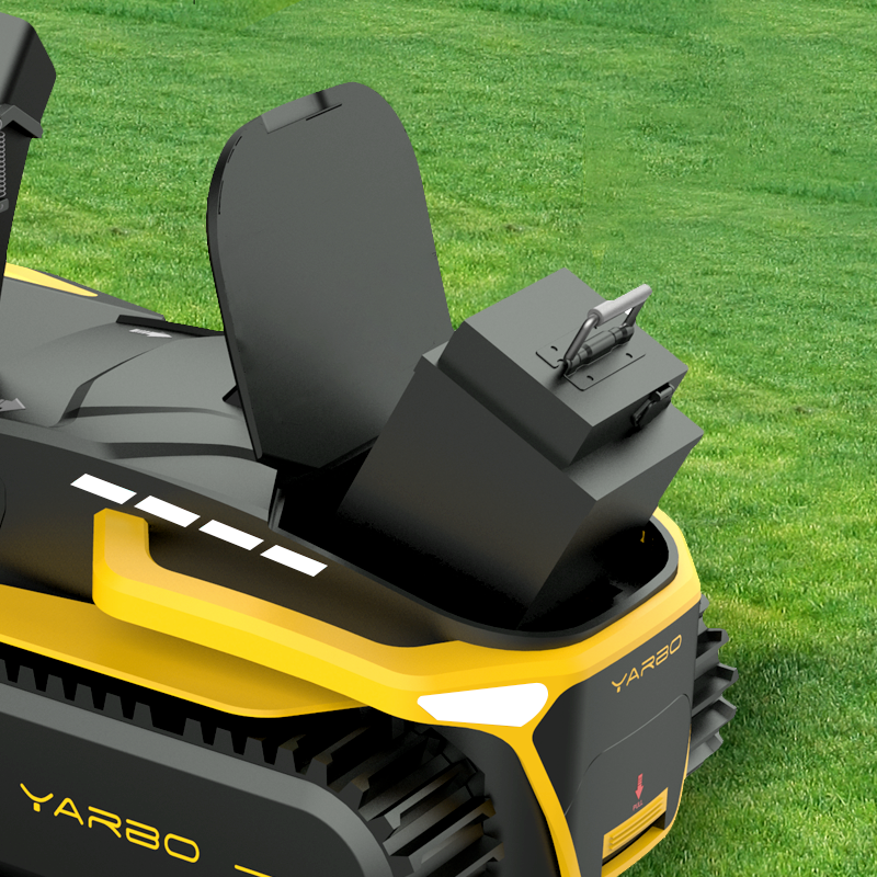 38.4Ah Y Series battery by YARBO, black rectangular unit with carrying handle, mounted on yellow and black lawn mower, side view on grass