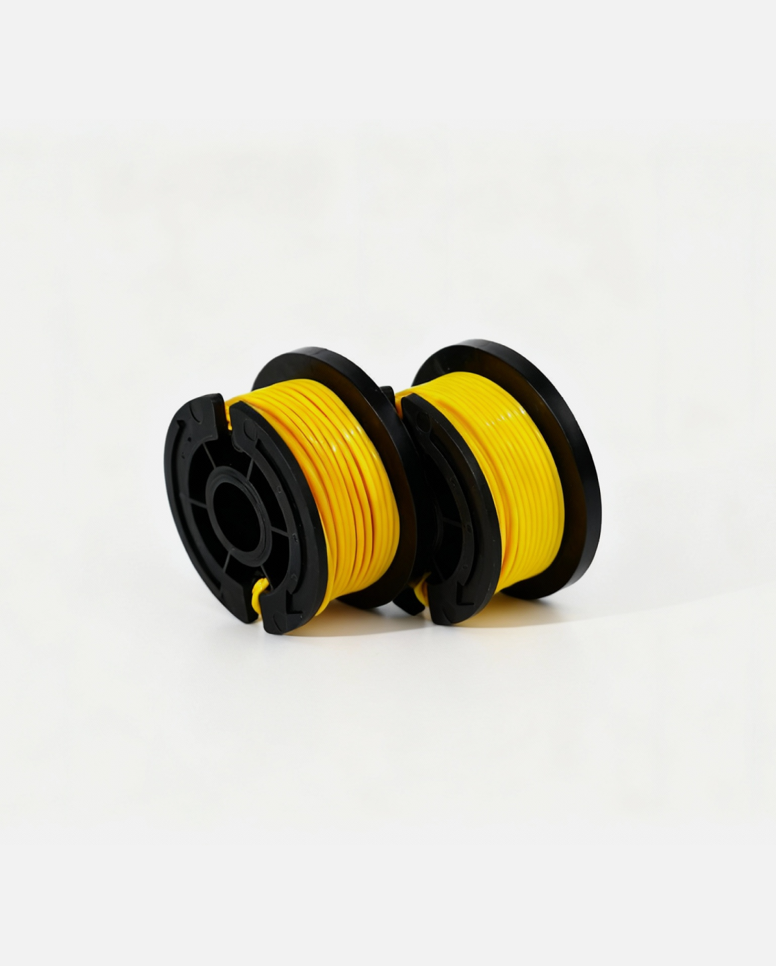 Yellow trimmer line spool with black plastic housing, side view, two units shown on white background